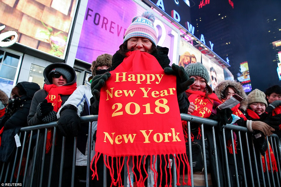 Some wore red scarfs that read 'Happy New Year' as they tried to keep warm while waiting for the ball to drop 