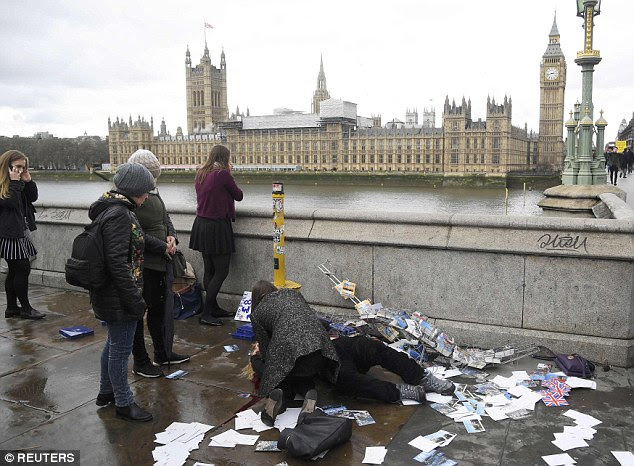 An injured woman is assisted after a man drove a 4x4 into pedestrians along Westminster Bridge on Wednesday afternoon