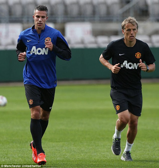 Straight into the action: Robin van Persie warms up alongside United coach Phil Neville in Sydney, hours after arriving for the second leg of the club's pre-season tour