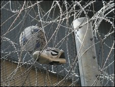 A football and trainer in barbed wire