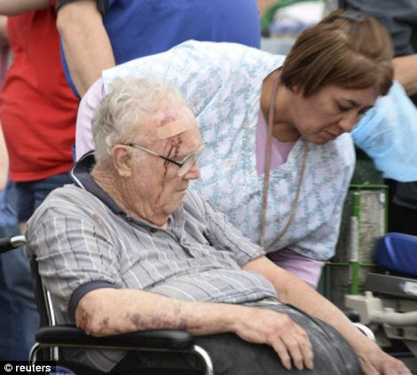 A nurse helps a older man that suffered a head injury