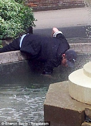Brazen: This man throws his arm deep into the water to steal the charity cash 