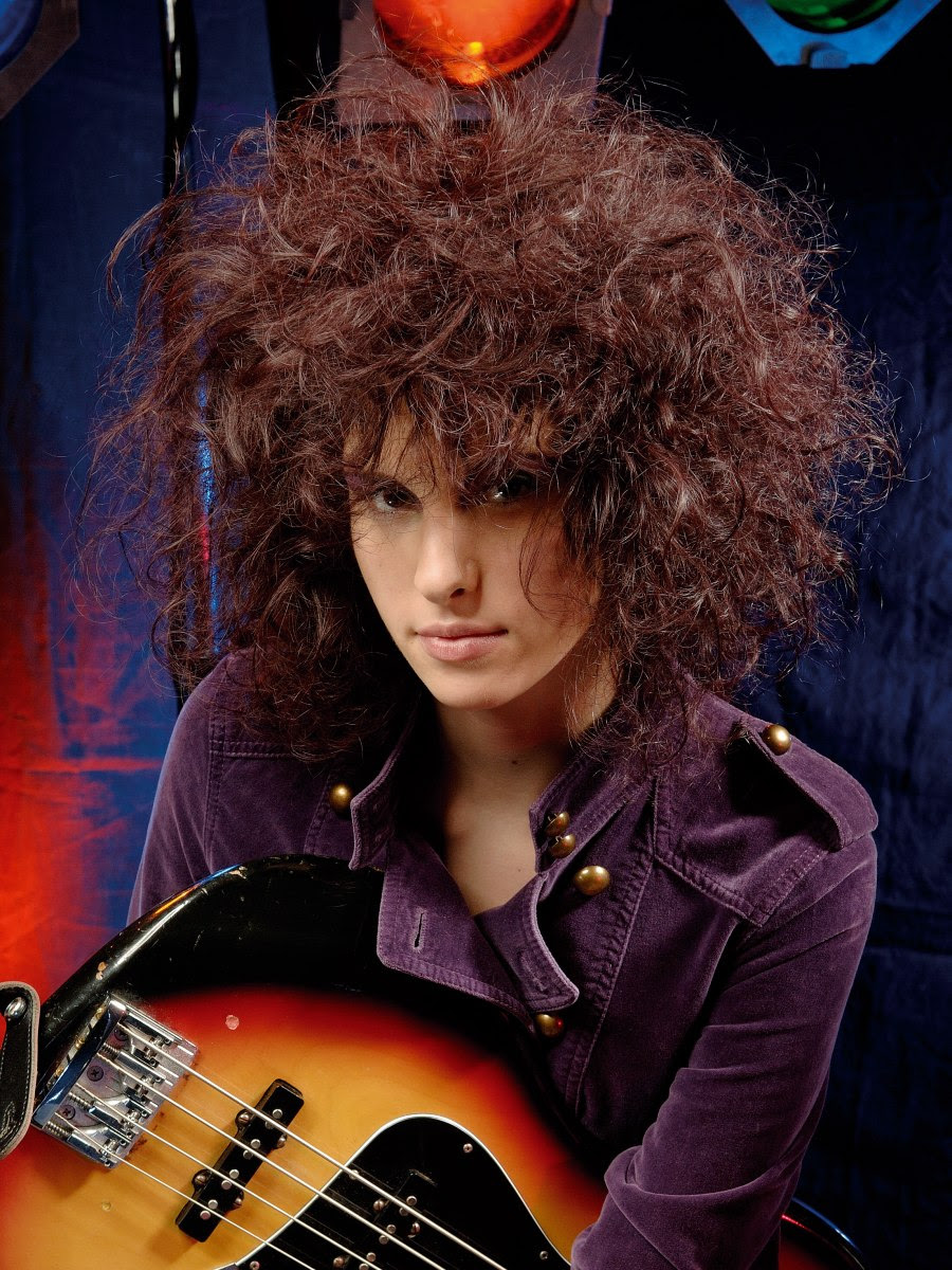 Long curly hair teased, kneaded and crushed for an 80s big 