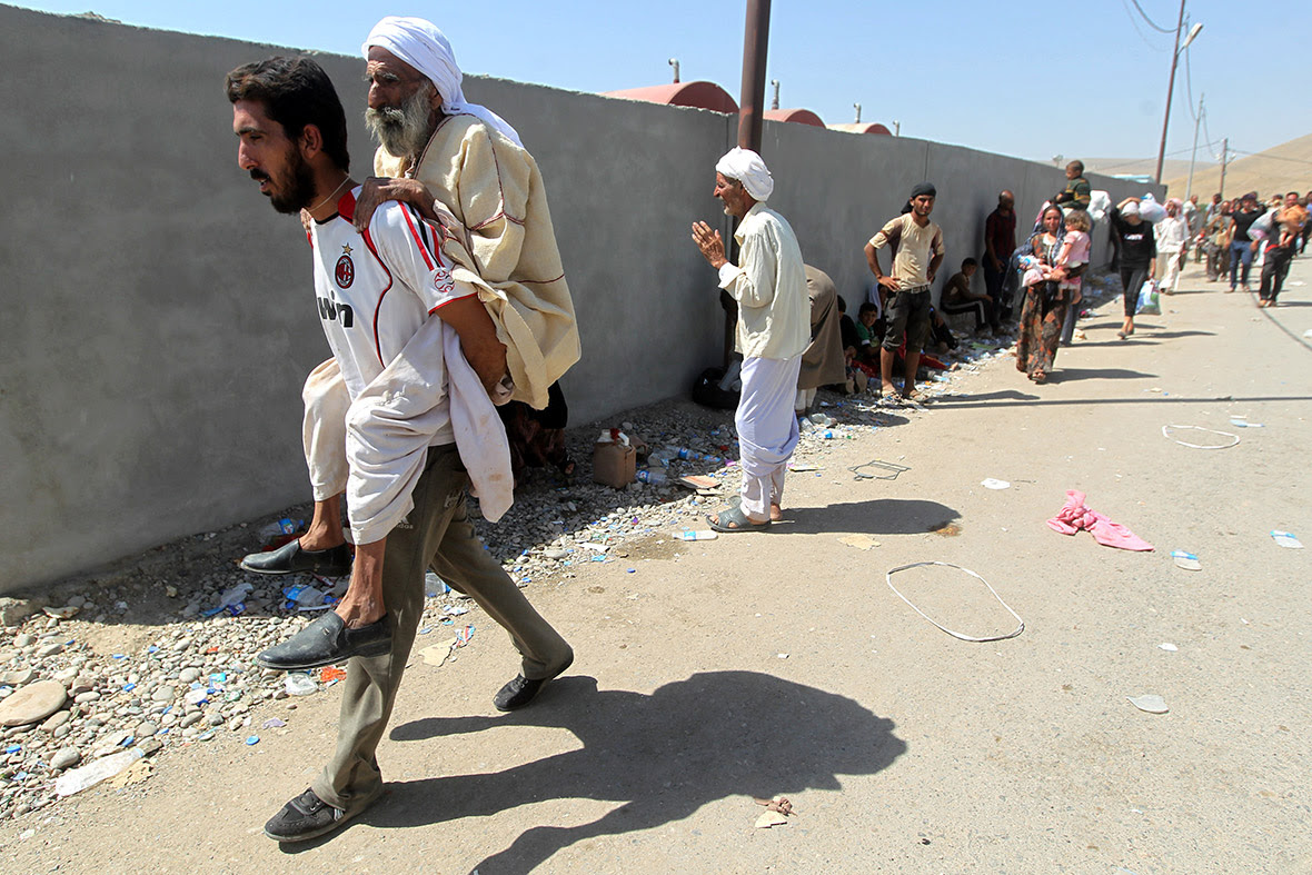 Displaced Iraqis from the Yazidi community cross the Fishkhabur bridge over the Tigris River into Syria.