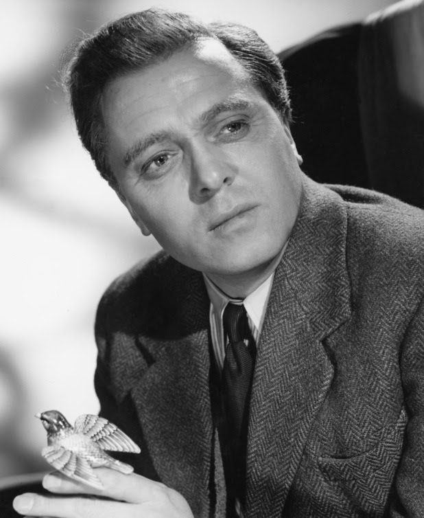 English actor and director Richard Attenborough holding a small model of a bird in a promotional portrait for 'Jet Storm', directed by Cy Endfield, 1959. 