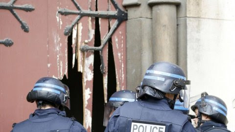 La policía francesa entran en la Iglesia un la iglesia de Saint-Denis después de romper la puerta con un hacha, durante la operación policial para capturar al presunto cerebro de los atentados de París.-  REUTERS / Jacky Naegelen