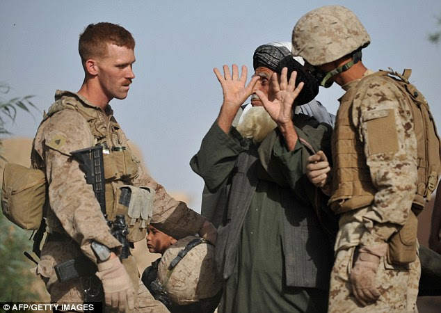 At work: Boston (left) talks to an Afghani man during a patrol in Sistani, Helmand Province in 2011