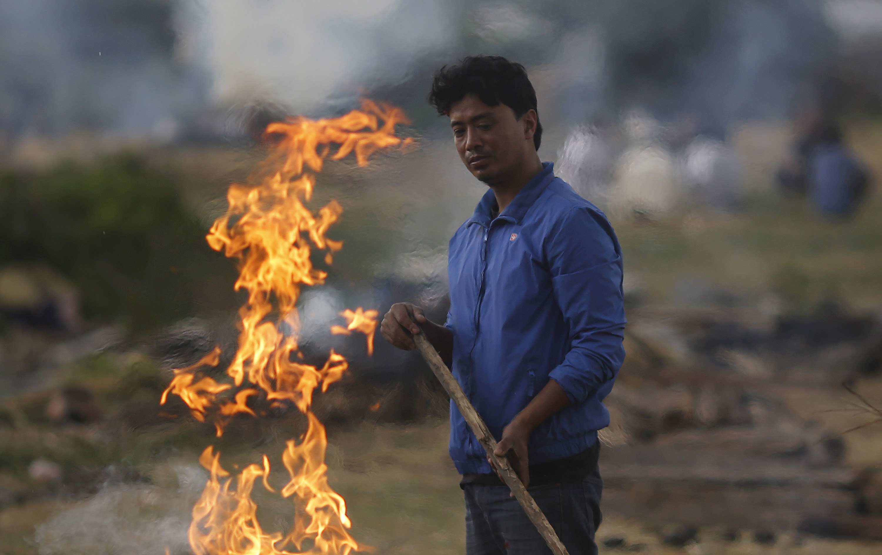 A man stands next to the burning pyre of a family member at a cremation ground after Saturday's earthquake in Bhaktapur, Nepal on Monday. Photo by Adnan Abidi/Reuters