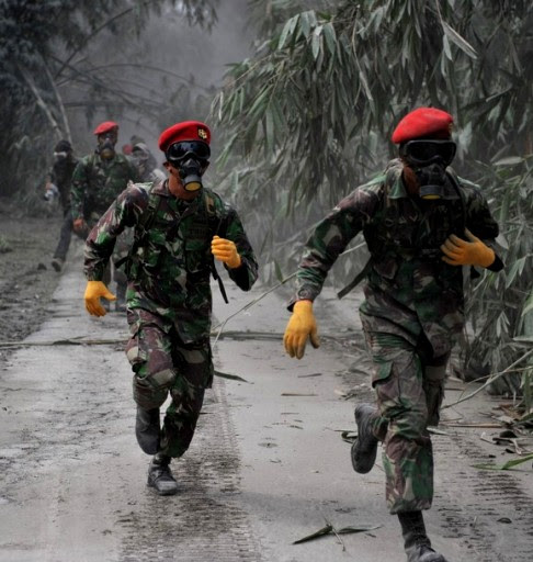 Indonesian army special forces wearing masks prepare to evacuate the victims of Mount Merapi eruption at Pejambon in Sleman, Yogyakarta, on November 8, 2010. International airlines were forced to reschedule dozens of flights to Indonesia yesterday as deadly Mount Merapi spewed ash into the sky, ahead of a visit by US President Barack Obama. The toll from a series of eruptions since late October rose to 132 as bodies were pulled from the volcanic sludge that thundered down on central Java on November 5, Merapi's biggest eruption since the 1870s. AFP PHOTO / Bay ISMOYO (Photo credit should read BAY ISMOYO/AFP/Getty Images)