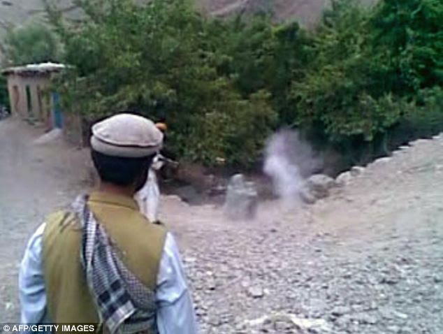 The man opens fire at Najiba as she is sitting with her back towards him as a man looks on