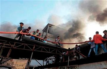 (AP Photo/A.M. Ahad). Bangladeshi firefighters and volunteers work to douse a fire at a two-storied garment factory in Dhaka, Bangladesh, Saturday, Jan.26, 2013.
