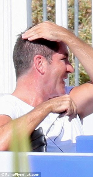 Giving it a go: The music mogul laughed as he jumped inside while Lauren snapped away 