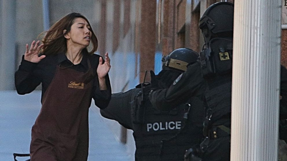 PHOTO: An armed tactical response police officer grabs a hostage as she flees from a cafe under siege at Martin Place in the central business district of Sydney, Australia, Dec. 15, 2014. 