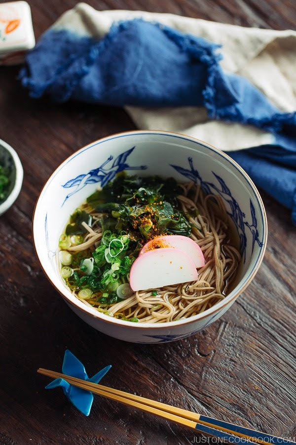 Toshikoshi Soba Noodle Soup with fish cake and wakame seaweed in a Japanese bowl.