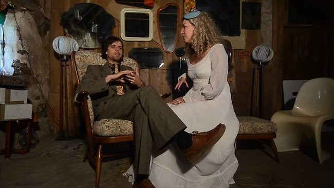 Pasangan Georgina Porteous dan Sid Innes duduk di kursi pengantin tanpa hiasan sehabis pemberkatan oleh pendeta.