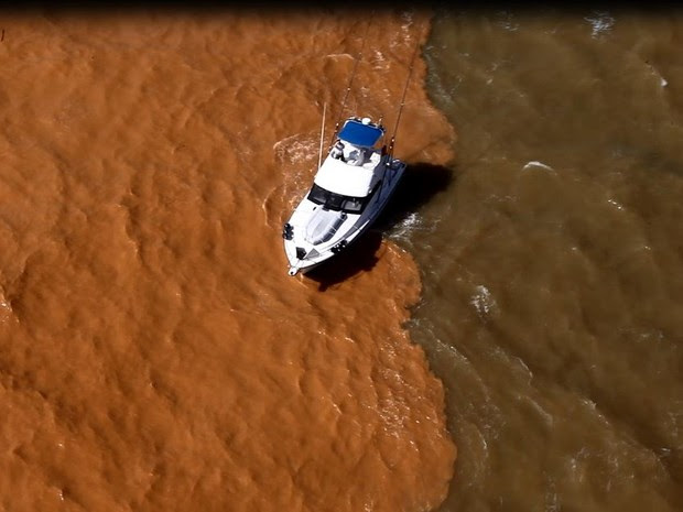 Barco passa por divisa entre lama e mar, em Regência, Linhares (Foto: Marcello Lourenço/ Arquivo Pessoal)