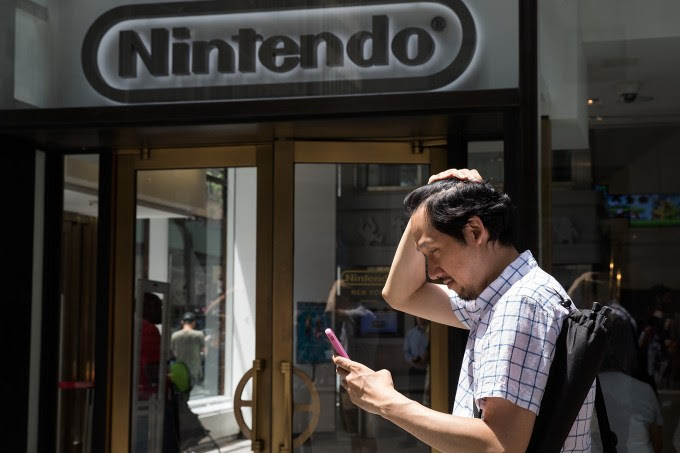 NEW YORK, NY - JULY 11: A man plays Pokemon Go on his smartphone outside of Nintendo's flagship store, July 11, 2016 in New York City. The success of Nintendo's new smartphone game, Pokemon Go, has sent shares of Nintendo soaring. (Photo by Drew Angerer/Getty Images)