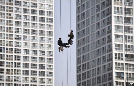 Window cleaners between high-rise buildings in Beijing, China