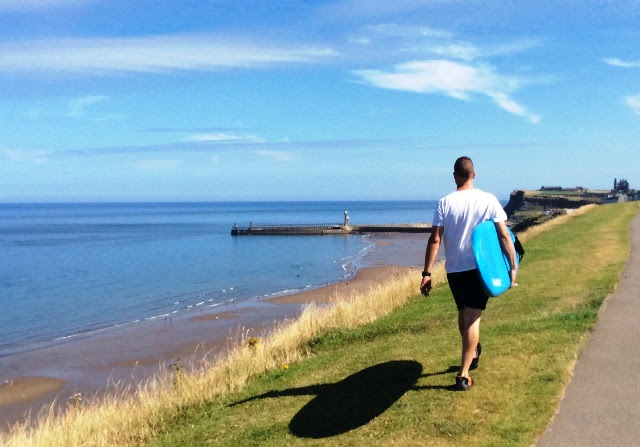 Surfer walking along Whitby Cliffs, North Yorkshire - zoedawes