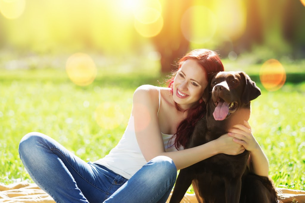 Young girl with retriever on walk in summer park