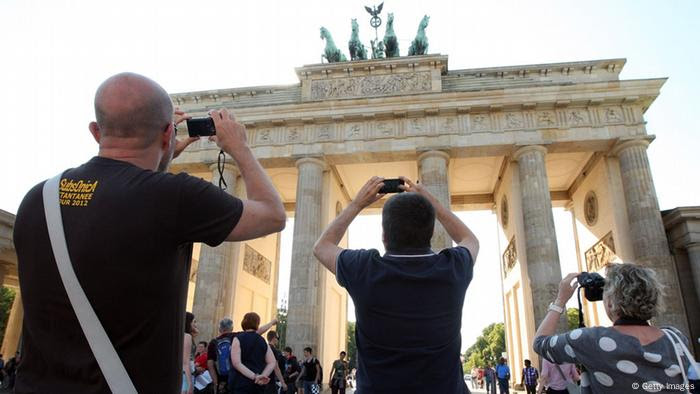 Tourists take photos of the Brandenburg Gate