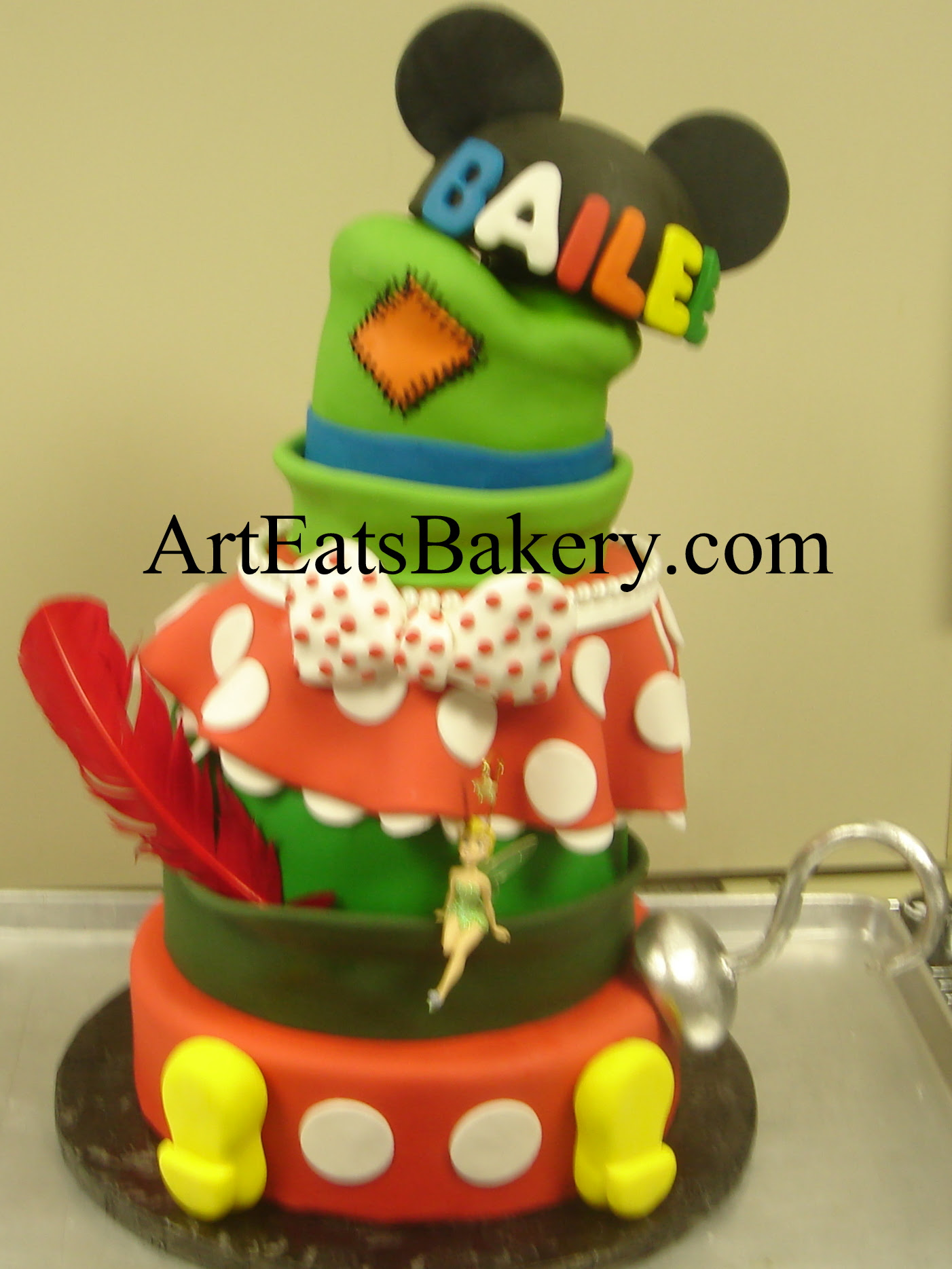 Mickey's pants and Minnie Mouse skirt, Goofy's, Peter Pan's and mouse ears hats mad hatter sweet sixteen birthday cake design with edible Captain Hook's hook, polka dot bow, and Mickey's feet.jpg