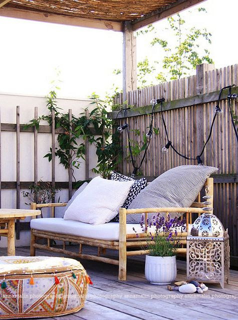 it's cosy and humble but I could be quite happy in this outdoor living spaces by the style files with the scalloped lights, lantern, and fantastic ethnic ottoman