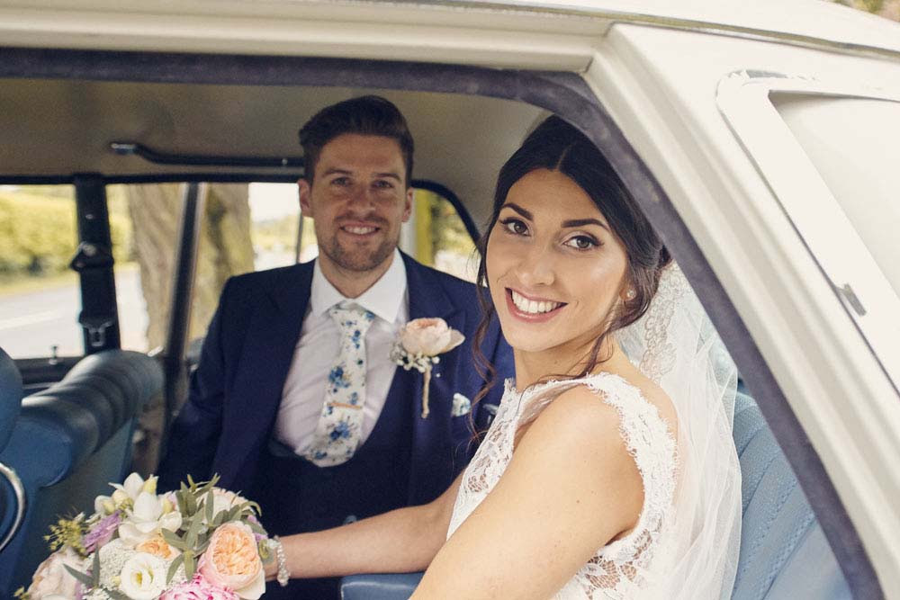 bride and groom in back of wedding car - www.helloromance.co.uk