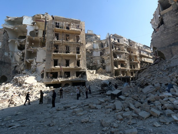 Sírios observam destruição em Shaar, a nordeste de Aleppo, neste sábado (Foto: AFP)