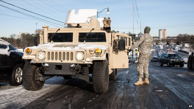 A National Guardsman prepared to tow a car in Dunwoody, Georgia, on 29 January 2014 