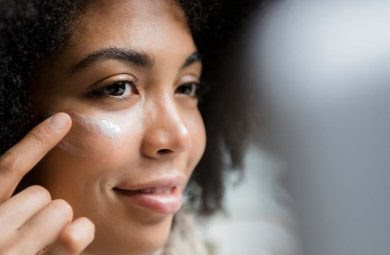 A woman applying eye cream.