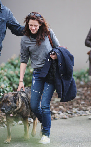 Kristen Stewart pets a dog.
