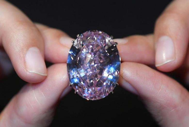 A model poses with a 59.60-carat mixed cut diamond known as ''The Pink Star'', the largest Internally Flawless Fancy Vivid Pink diamond ever graded by the Geological Institute of America (GIA), ahead of being auctioned in Hong Kong next month by Sotheby's which said it could fetch upwards of $60 million (GBP £48.4 million) to make it the most expensive diamond of its kind ever sold, in London, Britain, March 20, 2017. REUTERS/Toby Melville