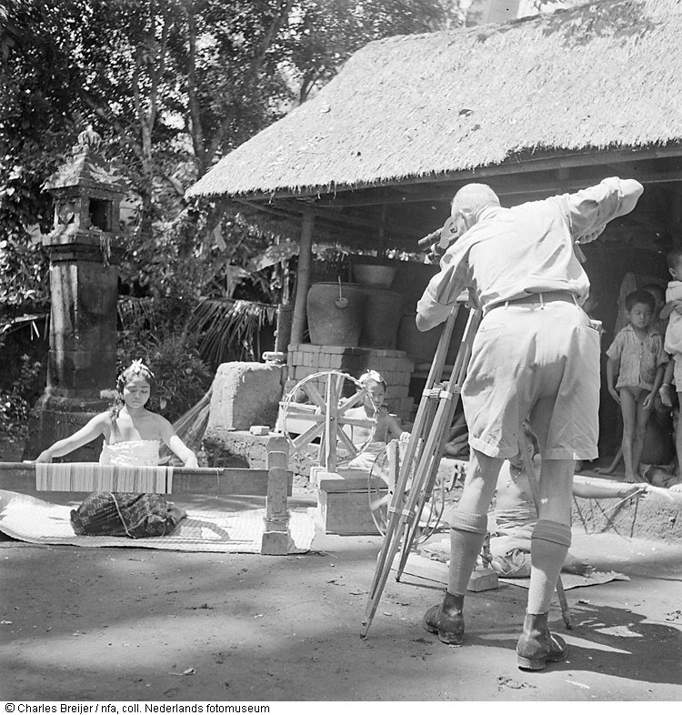 Jaap Zindler filmt in een kampong op Bali twee inheemse meisjes, werkend met een weefgetouw, Indonesië (1947)
