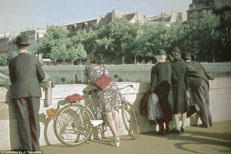 Leisure: A shapely woman leaning over the side of the bridge is the focus of this photograph