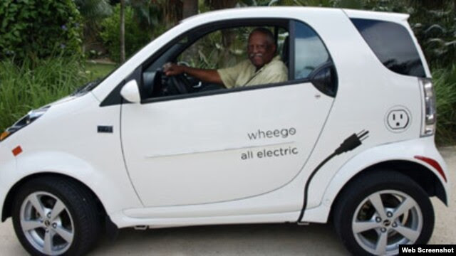 El propietario de Cayman Automotive posa junto a uno de sus autos eléctricos.