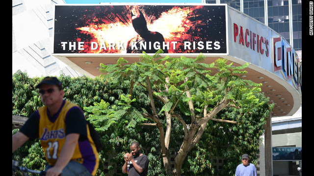 A cyclist and pedestrians pass a theater showing the latest Batman movie in Hollywood, California, on Friday. Warner Brothers said it was "deeply saddened" by Friday's massacre at a Colorado screening of "The Dark Knight Rises."