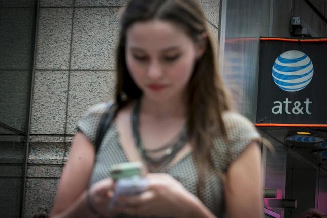 A woman uses her phone outside the AT&T store in New York's Times Square, June 17, 2015. REUTERS/Brendan McDermid