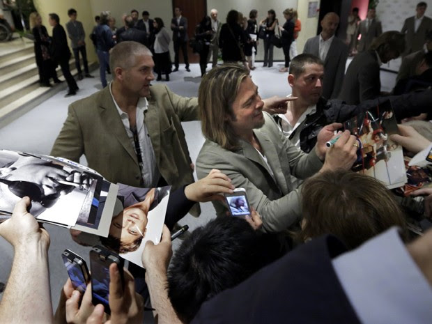 Ator americano Brad Pitt distribui autógrafos em chegada ao Festival de Cannes nesta terça-feira (22) (Foto: Eric Gaillard/Reuters)