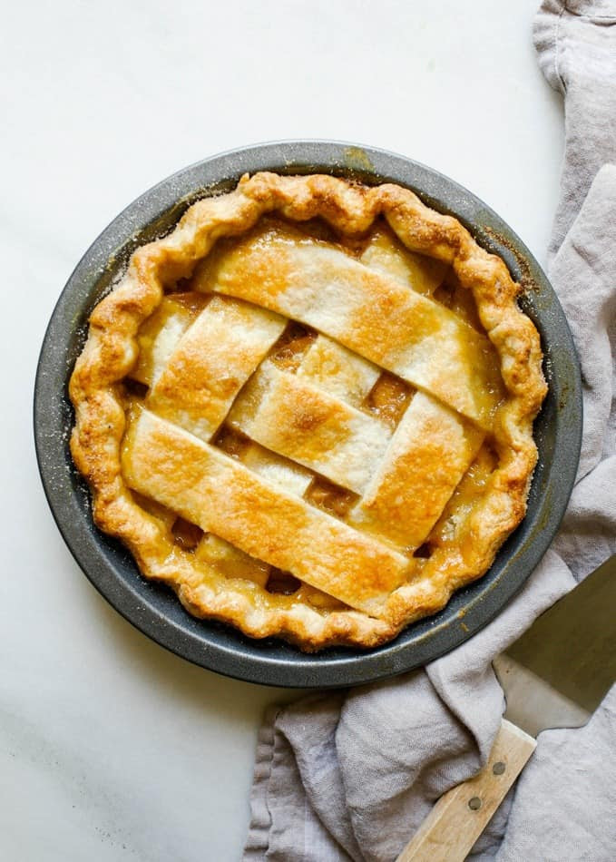 Peach Lattice Pie by Wood and Spoon blog. This is an all butter double pie crust with bourbon filled with cinnamon and vanilla bean peaches, all baked into a classic southern pie. the recipe is from Amber Wilson of "For the love of the south" cookbook. Find the recipe and how to for this chunky lattice summer dessert on thewoodandspoon.com by Kate wood.