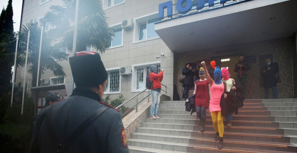 Image: Masked members of Pussy Riot leave a police station in Adler during the 2014 Sochi Winter Olympic