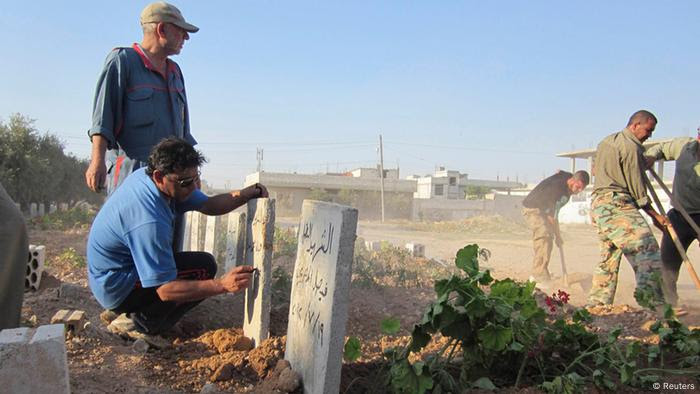 A man writes names on fresh graves of people whom activists say were killed by forces loyal to Syria's President Bashar al-Assad, after their funeral at the Qusseer neighbourhood of Homs  July 19, 2012. Picture taken July 19, 2012.  REUTERS/Shaam News Network/Handout  (SYRIA - Tags: POLITICS CIVIL UNREST TPX IMAGES OF THE DAY) FOR EDITORIAL USE ONLY. NOT FOR SALE FOR MARKETING OR ADVERTISING CAMPAIGNS