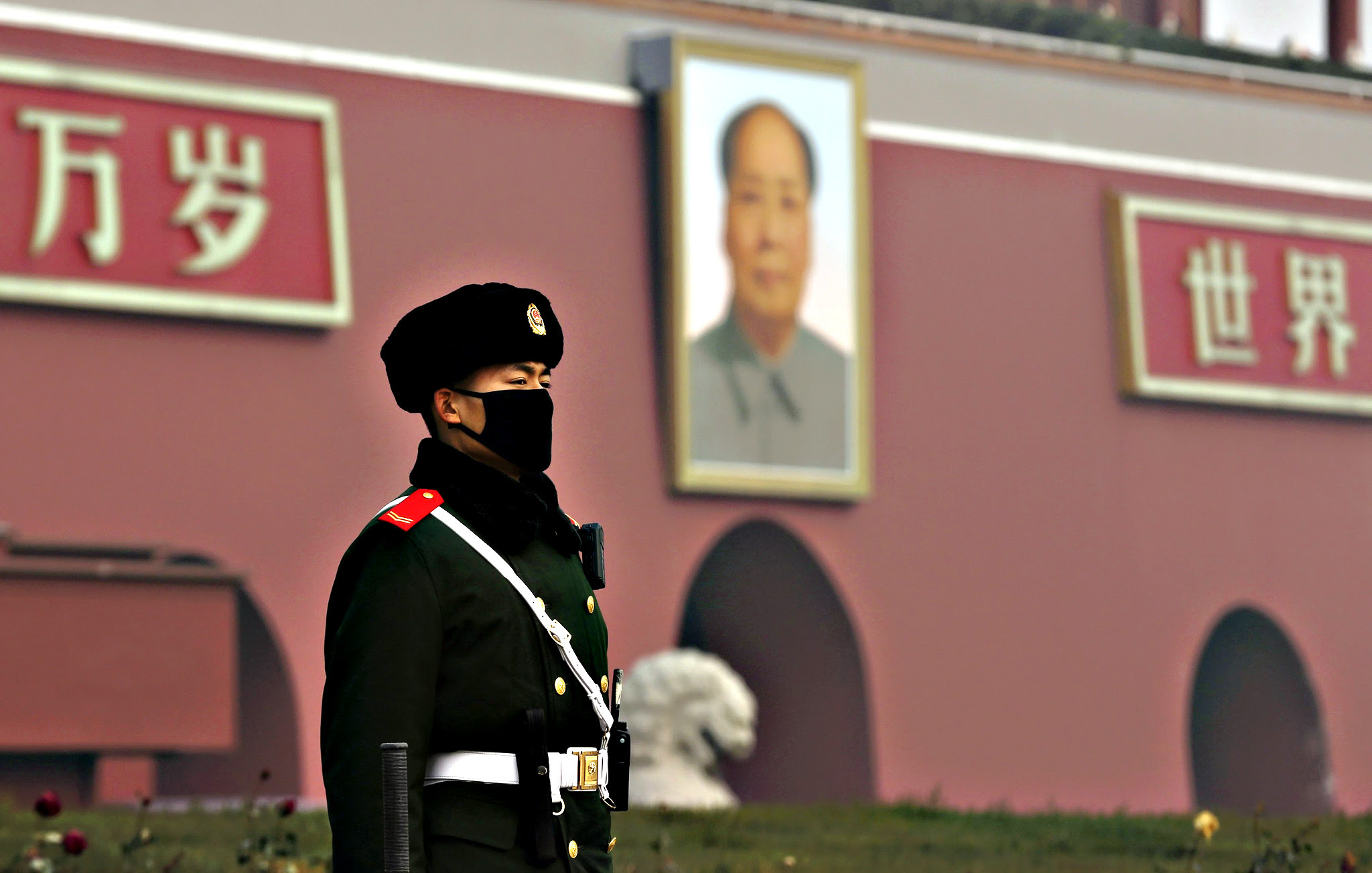 A paramilitary policeman wearing a mask stands guard in front of the giant portrait of Chinese late chairman Mao Zedong, amid heavy smog after the city issued its first ever "red alert" for air pollution in Beijing, China, December 9, 2015. Picture taken December 9, 2015.
