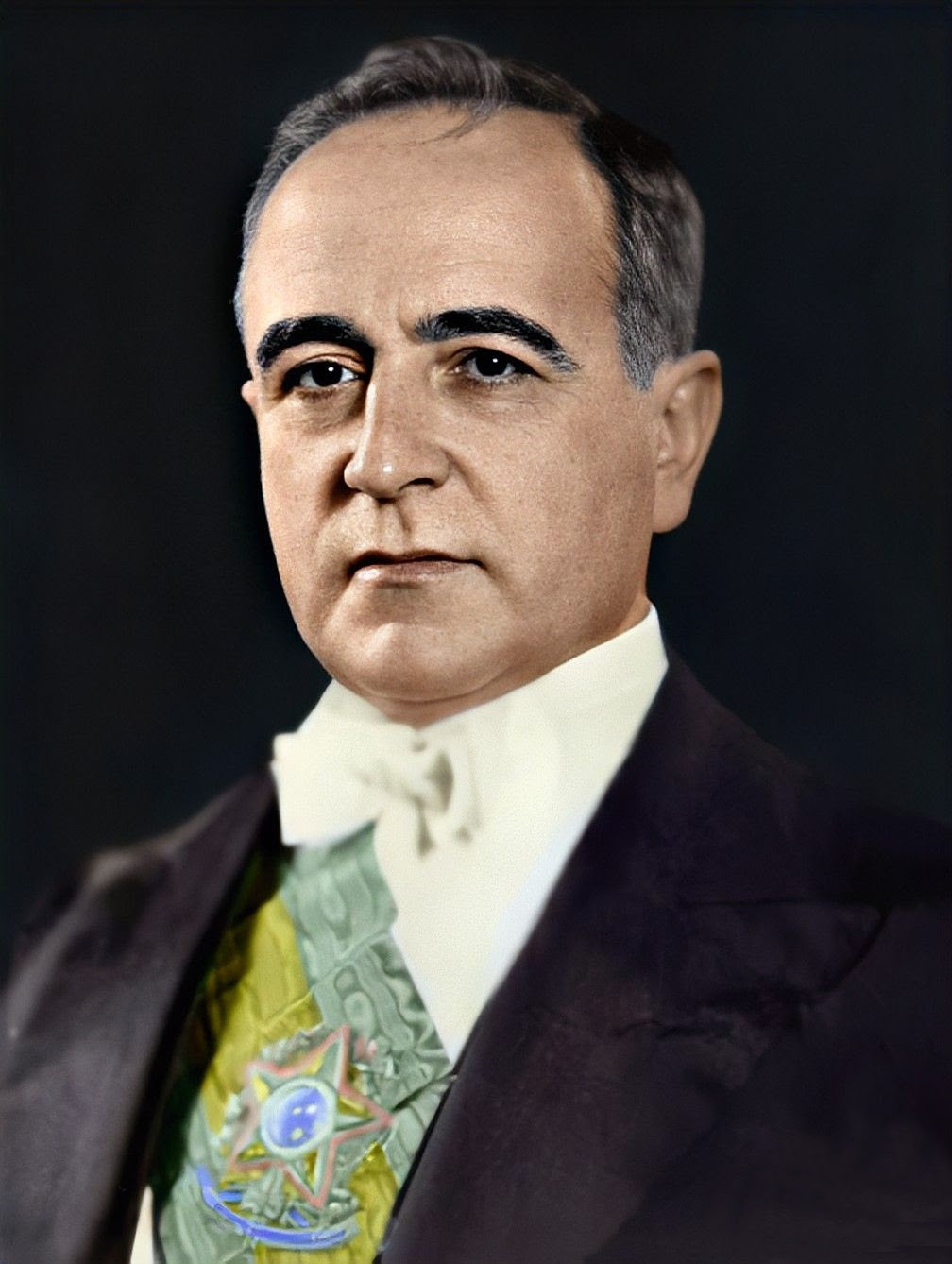  Houve muitos que consideraram um exagero retórico o uso do termo revolução para designar o ocorrido em 1930. Na realidade, segundo esse ponto de vista, a chamada Revolução de 1930 nada mais teria sido senão um golpe que deslocou do poder de Estado um setor da oligarquia brasileira, para dar lugar a um outro setor dessa mesma oligarquia. Evidentemente que a Revolução de 1930 não poder ser comparada à Revolução francesa de 1789 ou à Revolução russa de 1917. Ela não foi programada para produzir imediatas e radicais mudanças na estrutura sócio - produtiva do país. Decorreu, sobretudo, do efeito dos limites a que chegou a política econômica de proteção do café ante à violenta crise do capitalismo mundial. Assim vista, a Revolução de 1930 se inscreve na vaga de instabilidade política que tomou conta da América Latina na década de 30, a qual produziu grandes agitações e golpes militares no Peru (1930), na Argentina (1930), no Chile (1931), no Uruguai (1933), em Cuba (1933) e nas repúblicas centro-americanas, no mesmo período. O que não significa dizer, no entanto, que a Revolução de 1930 não tenha sido importante para o nosso passado. Pelo contrário. A Revolução de 1930 foi decisiva para a mudança de rumos da história brasileira. Ao afastar do poder os fazendeiros do café, que o vinham controlando desde o governo de Prudente de Morais, em 1894, pavimentou o caminho para uma significativa reorientação da política econômica do país. Tendo cortado o cordão umbilical que unia o café às decisões governamentais atinentes ao conjunto da economia e da sociedade brasileiras, a Revolução ensejou uma dinamização das atividades industriais. Até 1930, os impulsos industrialistas derivavam do desempenho das exportações agrícolas.    A partir de 1930, a indústria passa a ser o setor mais prestigiado da economia, concorrendo para importantes mudanças na estrutura da sociedade. Intensifica-se o fluxo migratório do campo para os centros urbanos mais industrializados, notadamente São Paulo e Rio de Janeiro, que, adicionado ao crescimento vegetativo da população, proporciona uma maior oferta de mão-de-obra e o aumento do consumo. Entre 1929 e 1937 a taxa de crescimento industrial foi da ordem de 50%, tendo-se verificado, no mesmo período, a criação de 12.232 novos estabelecimentos industriais no país. Desse modo, independentemente das origens sociais e das motivações mais imediatas dos revolucionários, não há dúvida de que a Revolução de 1930 constituiu uma ruptura no processo histórico brasileiro. Significado da era Vargas:  Getúlio implantou no país um novo estilo político - O POPULISMO - e um modelo econômico baseado no intervencionismo estatal objetivando desenvolver um capitalismo industrial nacional (processo de substituição de importações). Populismo é um fenômeno típico da América Latina,durante o séc. XX,no momento de transição para estruturas econômicas mais modernas. Ele significa "política de massas", ou seja, política que utiliza as massas como elemento fundamental nas regras do jogo. Caracteriza-se pelo contato direto da liderança e o povo. Através dele, Getúlio lutou contra as oligarquias, manteve o povo sob controle assumindo uma imagem paternalista e consolidou a indústria dentro de um esquema intervencionista.Não se tratava de povo no governo, mas de manipulação do povo para benefício do próprio líder carismático e das elites possuidoras. Governo provisório (1930-34) - fatos marcantes:  A Revolução constitucionalista de SP (1932): a pretexto de democratizar e constitucionalizar o país, os cafeicultores de SP tentaram voltar ao poder. Foram duramente reprimidos. Vargas, numa atitude claramente populista, concilia-se com os vencidos: nomeia paulistas para cargos chaves e mantém a política de valorização do café.    A constituição de 1934: inspirada na constituição democrática de Weimar (Alemanha), a 3 constituição brasileira foi promulgada com as seguintes características: federalismo, eleições diretas (a partir de 38 - até lá Vargas seria o presidente) e secretas, voto feminino, representação classista no congresso e leis sociais (salário mínimo e legalização dos sindicatos). Apesar dos avanços, ela não tocou na estrutura agrária e nem regulou as leis sociais o que impedia sua aplicação. Governo constitucional (1934-37) - fatos marcantes:  A "intentona" comunista (1935): as contradições sociais aguçadas com o desenvolvimento industrial fortaleceram o partido comunista. O objetivo do PC era criar alianças com setores mais progressistas da sociedade por isso criou a Aliança Nacional Libertadora (ANL) com um programa nacionalista, antifascista e democrático. Com a repressão de Vargas a ANL, os comunistas passaram a preparar uma insurreição armada. Devido a não participação popular, a intentonaterminou em uma "quartelada" fracassada liderada por Prestes. Os dois anos que se seguiram foram marcados pelo fechamento político (estado de sítio) que prenunciava a ditadura que se iniciaria em 1937. A ascensão da ideologia fascista: A ação integralista brasileira (AIB), liderada por Plínio Salgado, foi a expressão típica do modelo fascista no Brasil. Propunha o culto ao seu líder e uma retórica agressiva anticomunista e nacionalista. O integralismo apoiou entusiasticamente o Golpe de 37, no entanto, Vargas não dividiu os privilégios do poder com a AIB. O plano COHEN: Em determinado momento, o governo anunciou ter descoberto um plano comunista subversivo e o utilizou para dar o golpe de estado em 1937 cancelando as eleições de 1938. Na verdade, o plano era falso e foi apenas o pretexto para a ditadura. Iniciava-se o ESTADO NOVO. O Estado Novo (1937-45) - fatos marcantes:  A constituição de 1937 (a "polaca"):outorgada e fascista. Estabelecia que o presidente teria o poder nas mãos enquanto não se convocasse um plebiscito para aprová-la (o que não aconteceu). A ditadura: os partidos foram suprimidos, o legislativo suspenso, a censura estabelecida pelo departamento de imprensa e propaganda (DIP), centralizaram-se as funções administrativas através do departamento de administração do serviço público (DASP), as liberdades civis deixaram de existir. A economia: aprofundamento da industrialização através do processo de substituição de importações nos setores de bens de consumo não duráveis (tecidos e alimentos) e, principalmente, dos bens intermediários (metalurgia e siderurgia). O estado arcou com o ônus da industrialização numa demonstração de nacionalismo econômico: foram criados a vale do rio doce, a siderúrgica nacional e o conselho nacional de petróleo (nacionalização do refino, não a estatização). A questão social: criou-se o salário mínimo (1940), a consolidação das leis trabalhistas (1943) e os sindicatos passaram a ser controlados pelo ministério do trabalho. Deixava-se claro a combinação entre paternalismo estatal e fascismo. O estado passava a controlar as relações entre capital e trabalho (CORPORATIVISMO). A 2 guerramundial e a queda de Vargas: até 1941, o Brasil manteve-se neutro na guerra com declarada simpatia pelos fascistas. Em 1942, porém, a ajuda americana para construção da usina de Volta Redonda foi decisiva para que Vargas declarasse guerra ao EIXO. A contradição entre a política externa e a realidade interna do regime se torna patente forçando a abertura do regime. A abertura aconteceu em 1945: Surgiram partidos políticos como a UDN (burguesia financeira urbana ligada ao capital estrangeiro), o PSD (oligarquias agrárias), o PTB (criado por Vargas - massas operárias citadinas), o PCB (intelectualidade). Ao mesmo tempo, Getúlio adotava um discurso cada vez mais nacionalista earticulava o movimento QUEREMISTA, favorável a sua permanência nos cargo. Em 1945, o exército derrubou o presidente evitando o continuísmo.