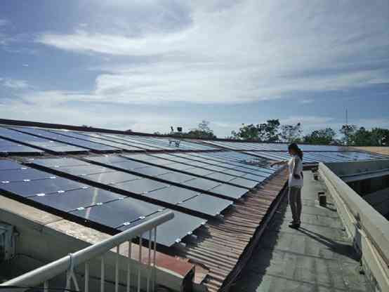 AN EMPLOYEE of Holy Name University in Tagbilaran City checks the 1,100 solar thin-film panels installed on the school’s rooftop.  HNU is the first academic institution to fully integrate solar-power energy system in Bohol province and the Visayas. LEO UDTOHAN/INQUIRER VISAYAS
