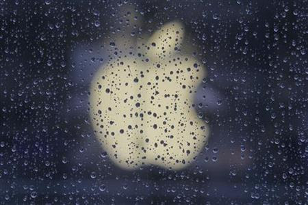 Raindrops are seen in front of an Apple logo outside an Apple store in Shanghai February 22, 2012. REUTERS/Aly Song