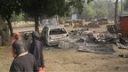 Children stand near the scene of an explosion in a mobile phone market in Potiskum, Nigeria, on 12 January 2015