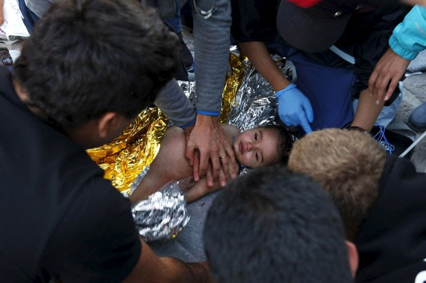 Médicos e paramédicos tentam reanimar criança após naufrágio de barco na costa da ilha de Lesbos nesta quarta-feira (28) (Foto: Giorgos Moutafis/Reuters)