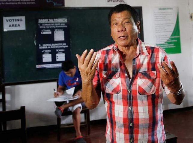 Presidential candidate Rodrigo ''Digong'' Duterte gestures as he speaks to reporters before casting his vote at a polling precinct for national elections at Daniel Aguinaldo National High School in Davao city in southern Philippines, May 9, 2016.    REUTERS/Erik De Castro