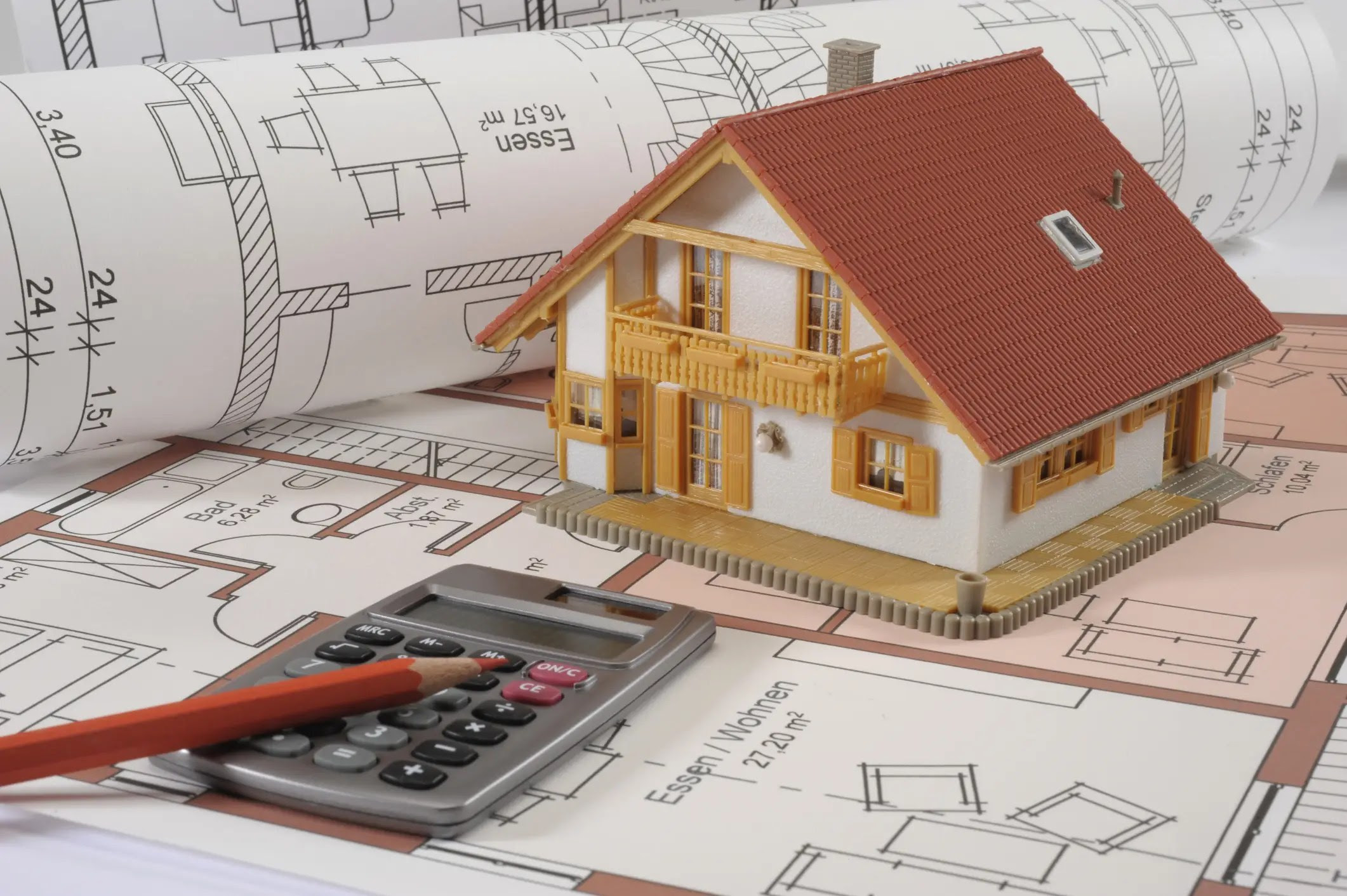Miniature house with calculator and building sketch as IMB illustration